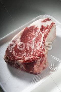 Bone-In Steak On Styrofoam Dish Wrapped In Plastic