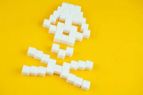 The bones skull made of sugar cubes on a yellow background. Sugar kills and Stock Photos