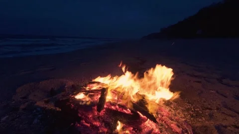 Bonfire Burning on a Dark Sandy Beach at Twilight near the Ocean 스톡 동영상 331533747