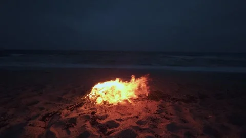 Bonfire Burning on a Dark Sandy Beach at Twilight near the Ocean 库存影片 331533824