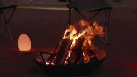 Bonfire burning in metal fire pit at desert camp, night Stock Footage 329237912