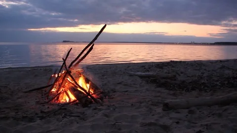 Bonfire burning on the riverbank  on the sunset Stock Footage 80939318