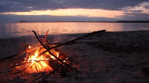 Bonfire burning on the riverbank  on the sunset Stock Footage 80939360