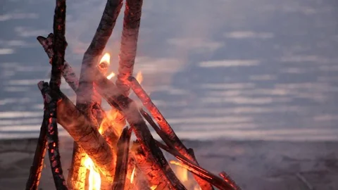 Bonfire burning on the riverbank  on the sunset Stock Footage 80976112