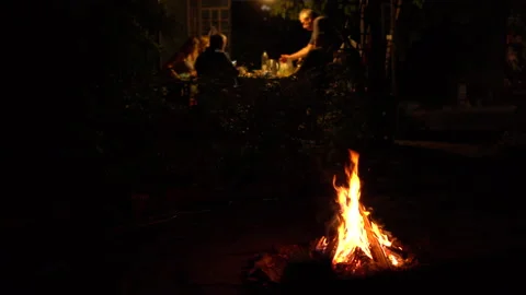 A bonfire burns in the night against the background of people in the gazebo 库存影片 136438301