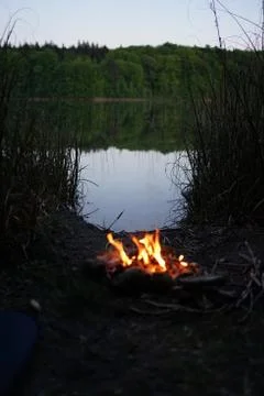 Bonfire at lake campsite  at dusk Stock Photos