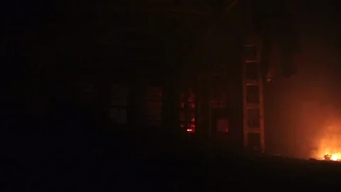 Bonfire or fire in a large abandoned hangar or storage at night Stock Footage 89360587