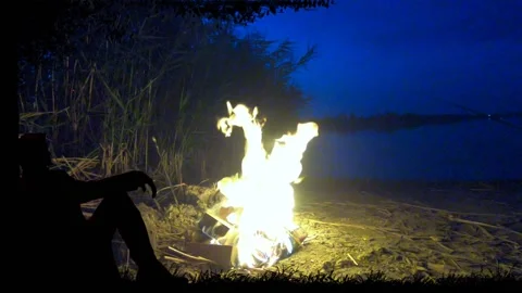 Bonfire by the river on a quiet night on the sandy shore. Stock-Footage 138385697