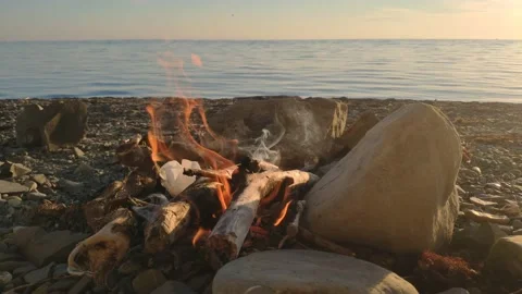Bonfire on the rocks on the background of the sea Stock Footage 155691382