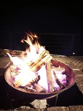 Bonfire With Split Logs Burning in a Metal Fire Container Stock Photos