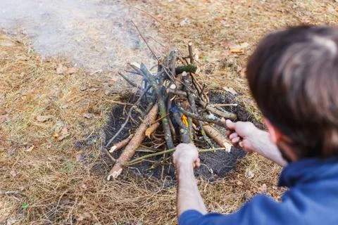 Bonfire in the spring forest on the background of withered grass. In the fram Stock Photos