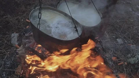 Bonfire with two cauldrons for cooking in the camp. Kindle Fire Video stock 169344062
