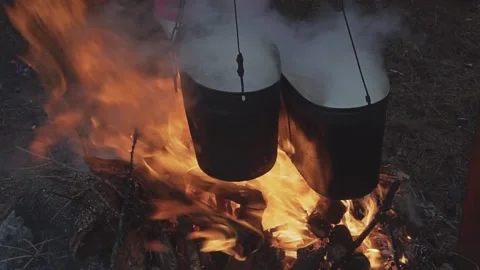Bonfire with two cauldrons for cooking in the camp. Kindle Fire Video stock 169344088