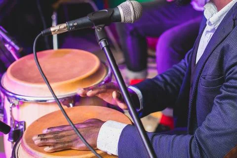 Bongo drummer percussionist performing on a stage with conga drums set kit .. Stock Photos