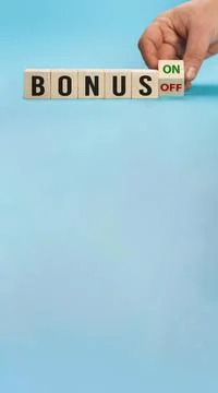 Bonus is going up or vice down. Hand is turning wooden cubes a dice and changes Stock Photos