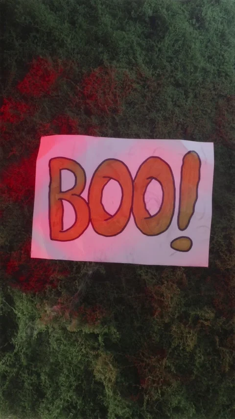 BOO graphic sign dropping abruptly onto red lit moss Видео 342423041