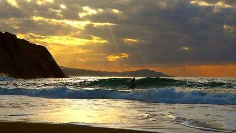 Boogie boarder flips in ocean wave at sunset in slow motion. Stock Footage 119568911