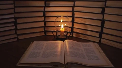 Book and candle on the table on the background of old books Stock Footage 77078665