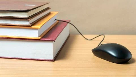 Book and computer mouse Stock Photos