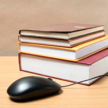 Book and computer mouse Stock Photos