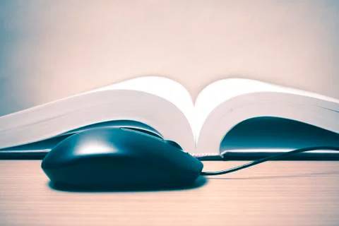 Book and computer mouse Stock Photos