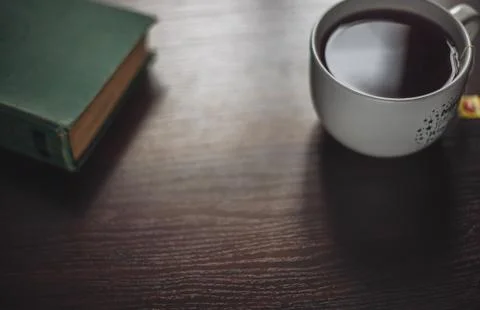 Book and cup of tea on  the table Stock Photos