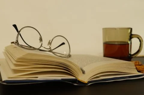 Book and glasses on the table Stock Photos