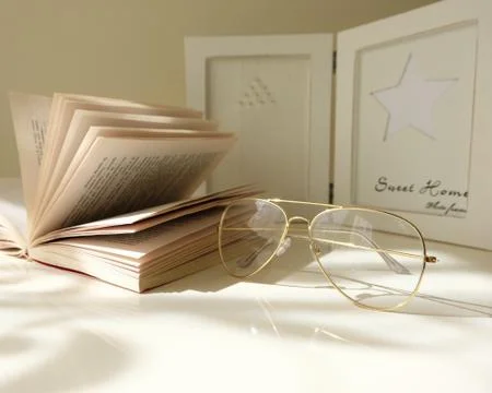 Book and glasses on the white table Stock Photos