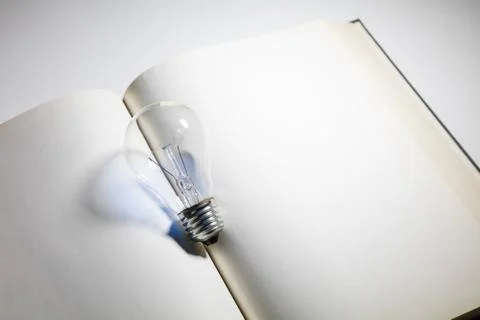 Book and light bulb Stock Photos