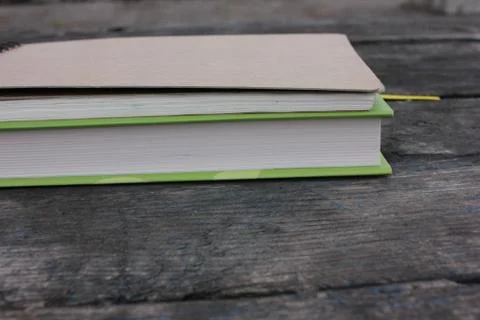 Book and notepad on rustic textured background outdoors Stock Photos