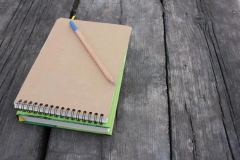 Book and notepad on rustic textured background outdoors Stock Photos