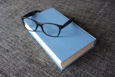 Book and a pair of glasses Stock Photos