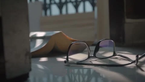 A book and spectacles kept in the room - old age, hobby, weak eyesight 스톡 동영상 260895059