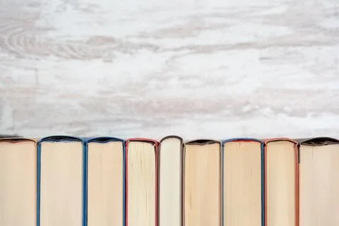 Book backs of different colors neat with a wooden background. Photo with Foto stock