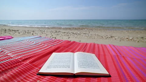 Book on Beach Mat by Relaxing Waves Stock Footage 250473822