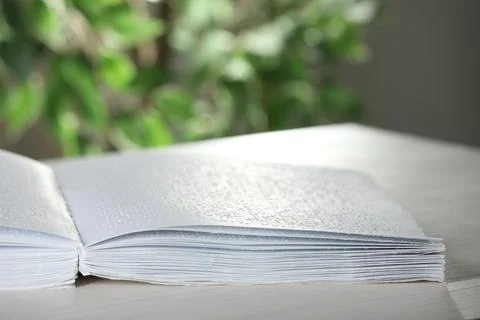 Book with Braille text on table, closeup. Education and leisure for blind p.. Foto stock