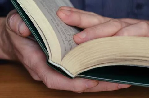 Book is in close-up hands. Stock Photos