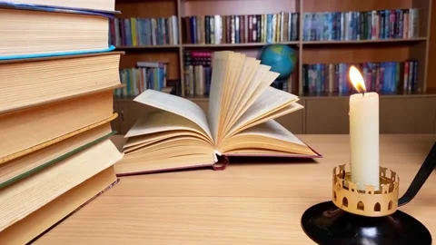 Book on desk in library at candle burning, Stock Footage 235347952