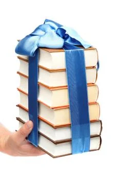 Book as a gift. a stack of books in female hand on a white background. Stock Photos