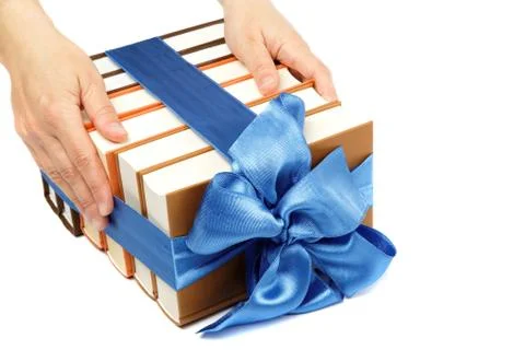 Book as a gift. a stack of books in female hands on a white background. Stock Photos