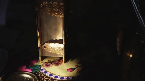 Book in a golden wrapper on a table in direct sunlight, close-up Stock Footage 129084604