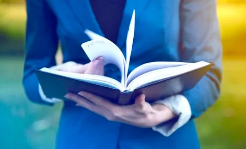 Book in hands of young student Stock Photos