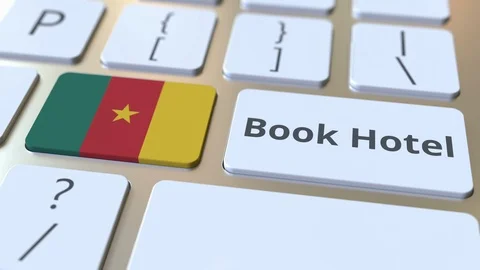 BOOK HOTEL text and flag of Cameroon on the buttons on the computer keyboard Stock Footage 112472089