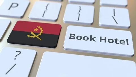 BOOK HOTEL text and flag of Angola on the buttons on the computer keyboard Stock Footage 112484245