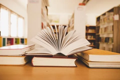 Book in library with old open textbook, stack piles of literature text arch.. Stock Photos