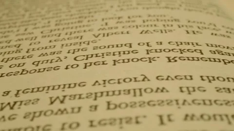 The book is lying on a white table, a man is reading it and turning the pages Stock Footage 297785311