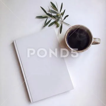 Book mockup on a table with a coffee mug PSD Template