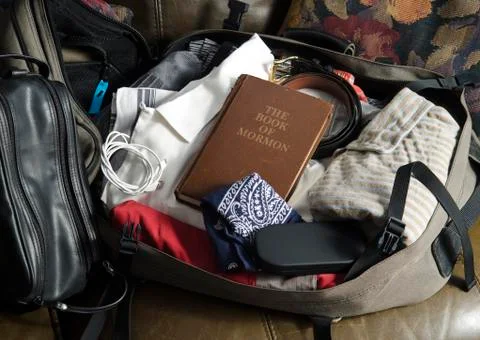 The Book of Mormon in packed mans suitcase Stock Photos