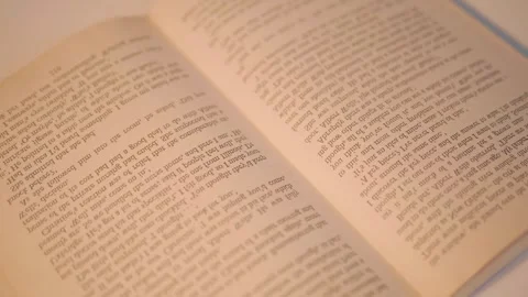 The book open in the middle is lying on a table and man turning the pages Stock Footage 297766423