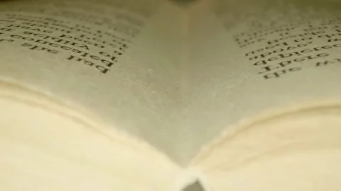 The book open in the middle is lying on a table and man turning the pages Stock Footage 297806255